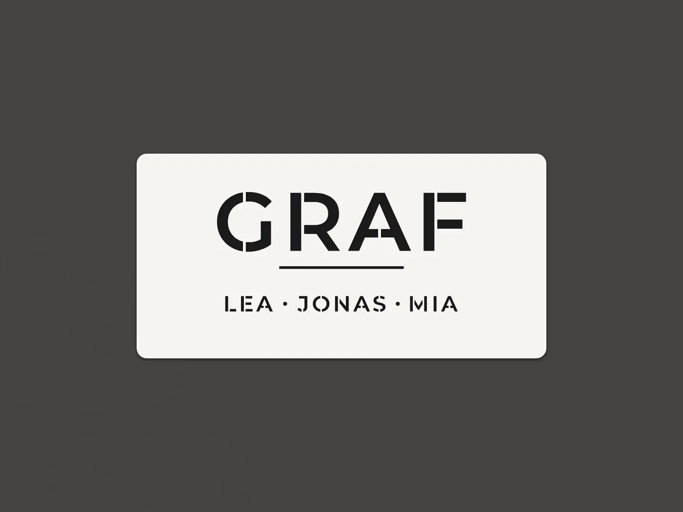 Weisses Familienschild mit dem Namen GRAF, darunter die Vornamen Lea, Jonas und Mia, an einer dunklen Haustür