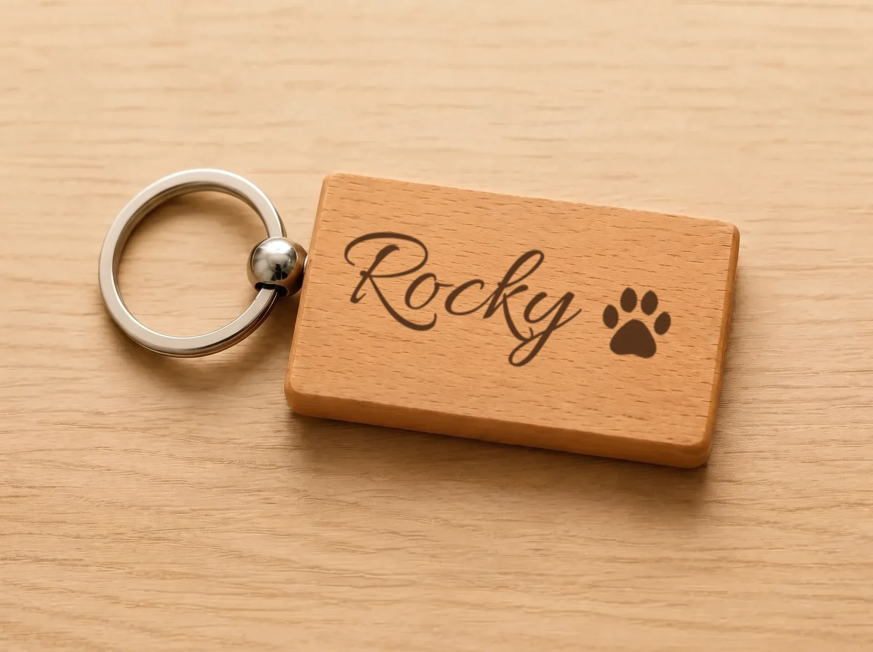 Holzanhänger mit dem Namen Rocky und einer Pfote graviert