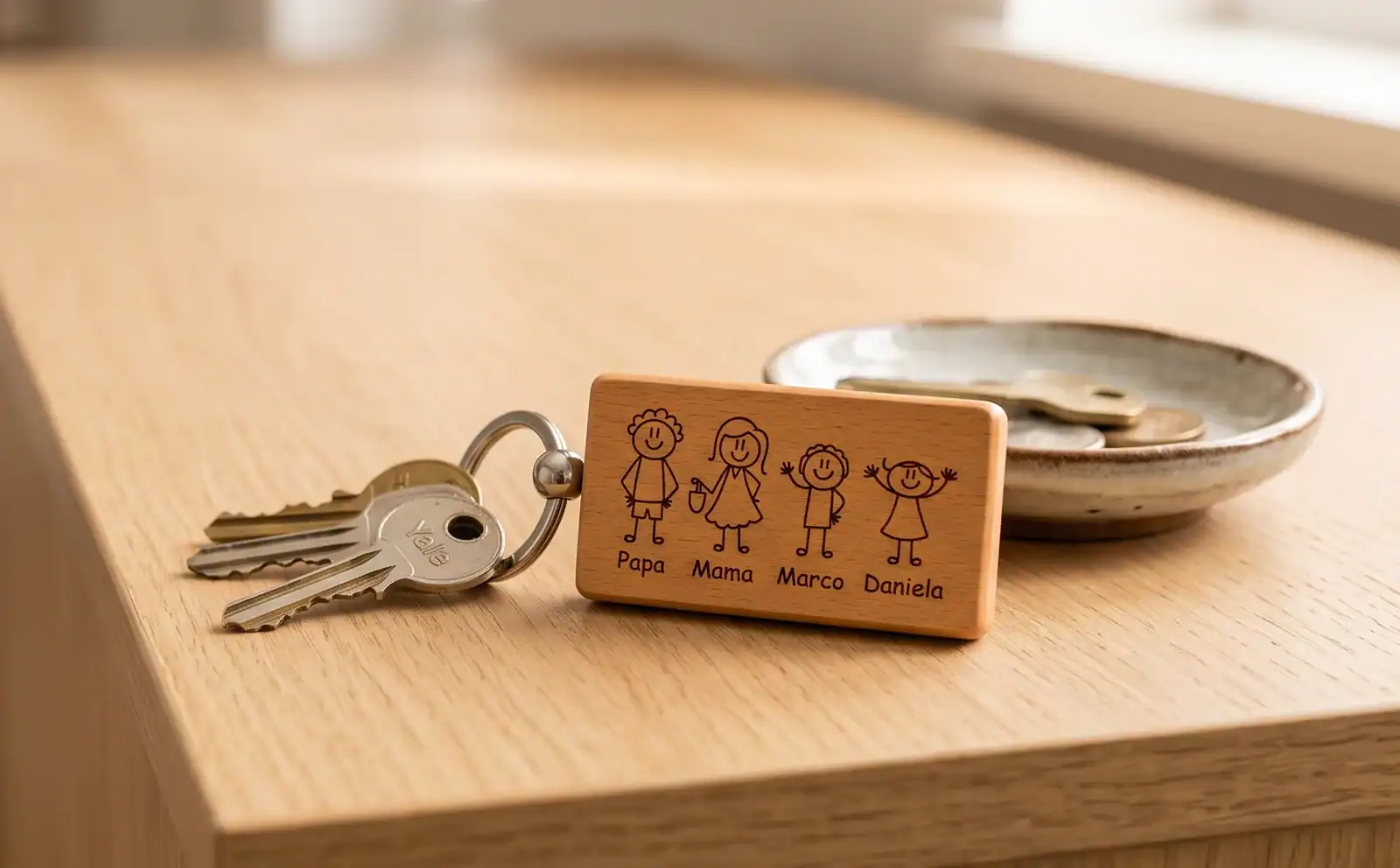 Holzanhänger mit gravierten Familienfiguren am Schlüsselbund auf einem Sideboard im Flur
